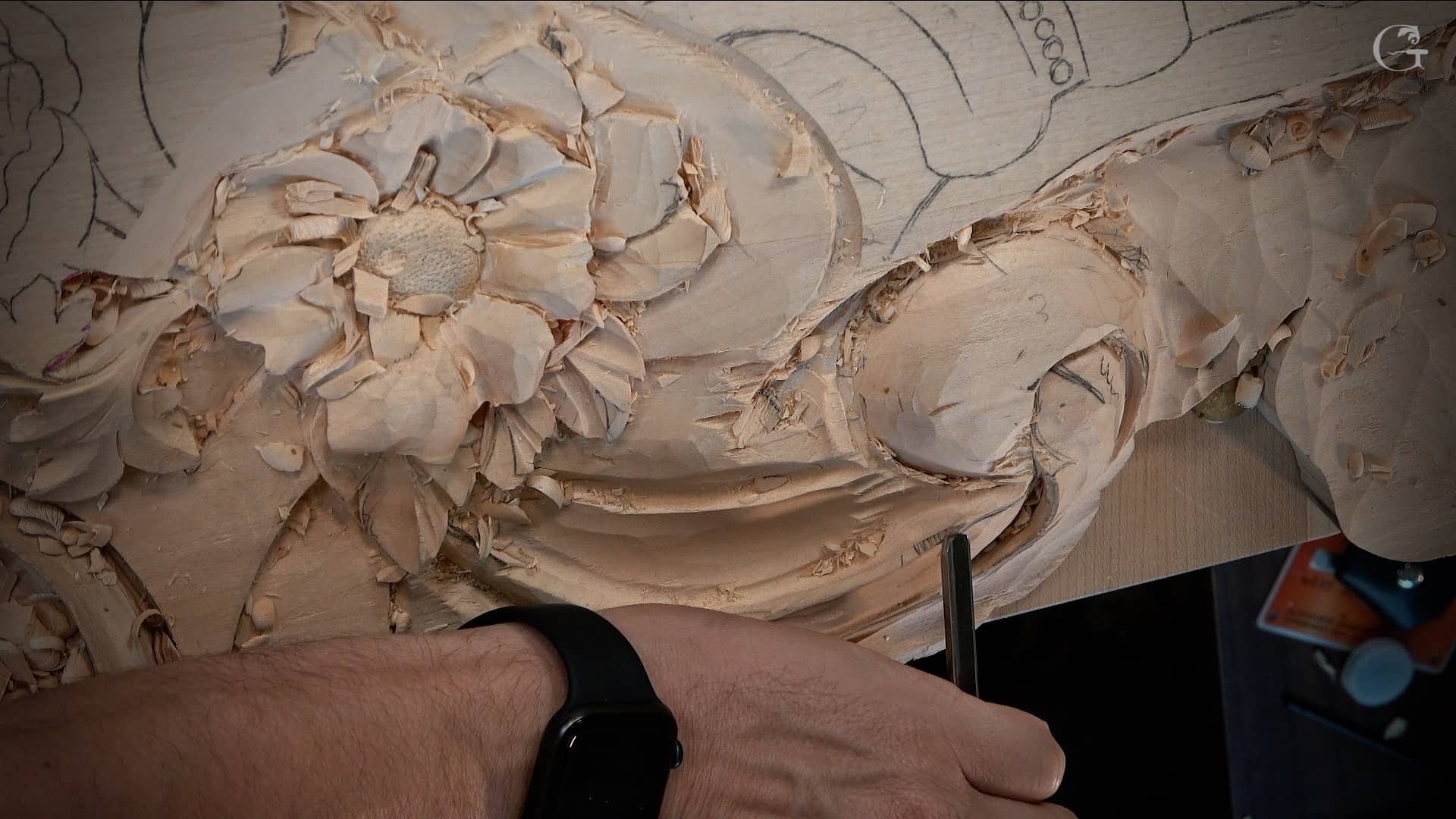 A close-up of a hand working on a detailed wood carving, showcasing intricate floral designs. The image highlights the texture of the wood and the precision of the carving tools. This scene perfectly captures the essence of wood carving classes, where students learn the art of crafting beautiful pieces from wood. Great for those looking for engaging wood carving lessons!