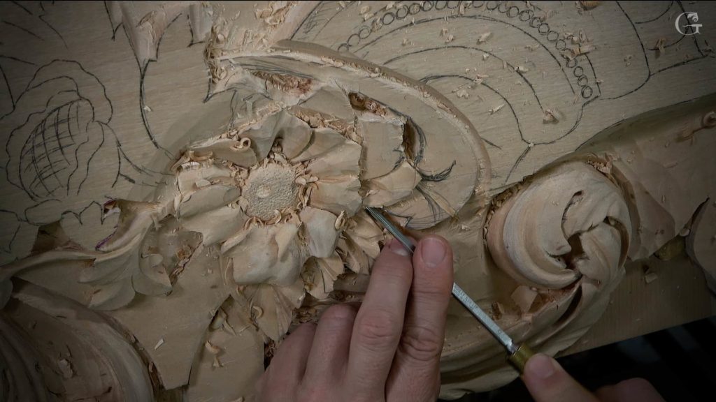A close-up image of a hand skillfully carving detailed floral patterns into a wooden piece. You can see the careful strokes taking shape with a specialized carving tool. This showcases the artistry involved in wood carving, highlighting the beauty of craftsmanship. Perfect for promoting wood carving classes and lessons!