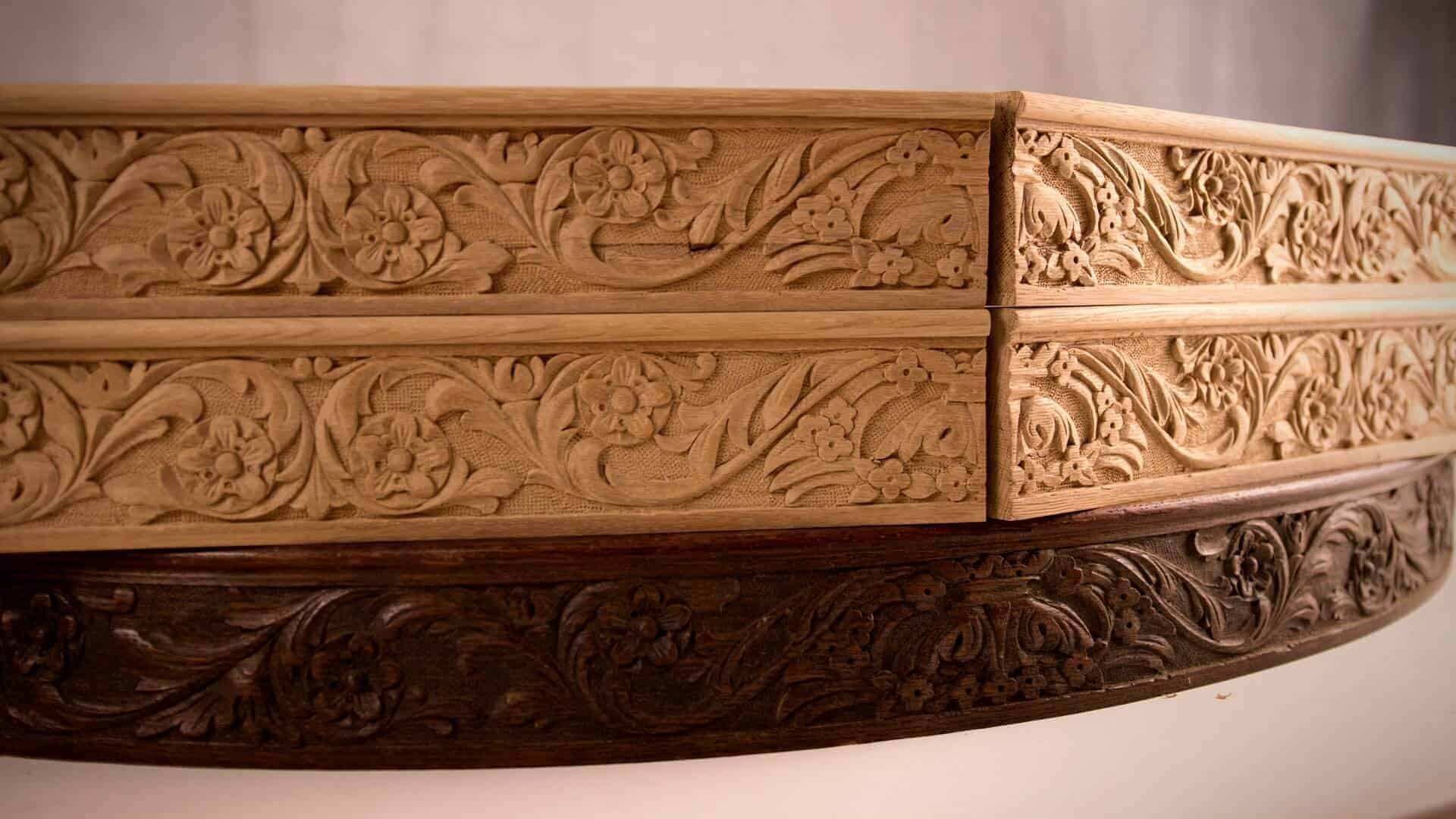 Alt text: Close-up of beautifully carved wooden drawer fronts featuring floral designs. The piece showcases detailed wood carving techniques, perfect for those interested in wood carving classes and lessons.