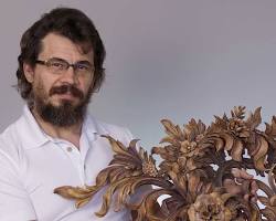 A person proudly holding an intricate wooden floral carving. This image showcases the beauty of wood carving, highlighting creativity and skill. Perfect for anyone interested in wood carving classes or lessons!