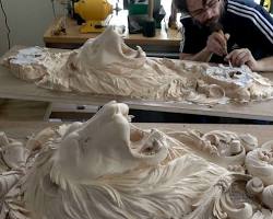 A person is focused on carving detailed lion sculptures on a workbench, showcasing skill and creativity in wood carving. Perfect for those interested in taking wood carving classes or lessons to enhance their craft!