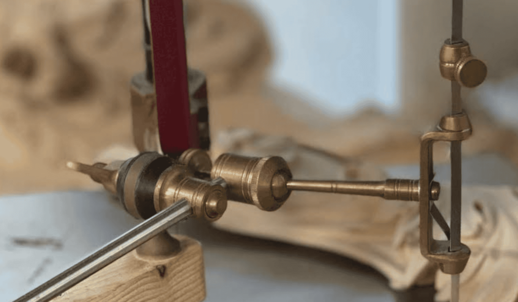 WOODCARVING LESSONS: Photo of an old tool with brass parts and a wooden base, often used for precise measurements or adjustments. Learn how to use a pointing machine to improve your woodcarving skills with Woodcarver Grabovetskiy. - Wood Carving tutorials