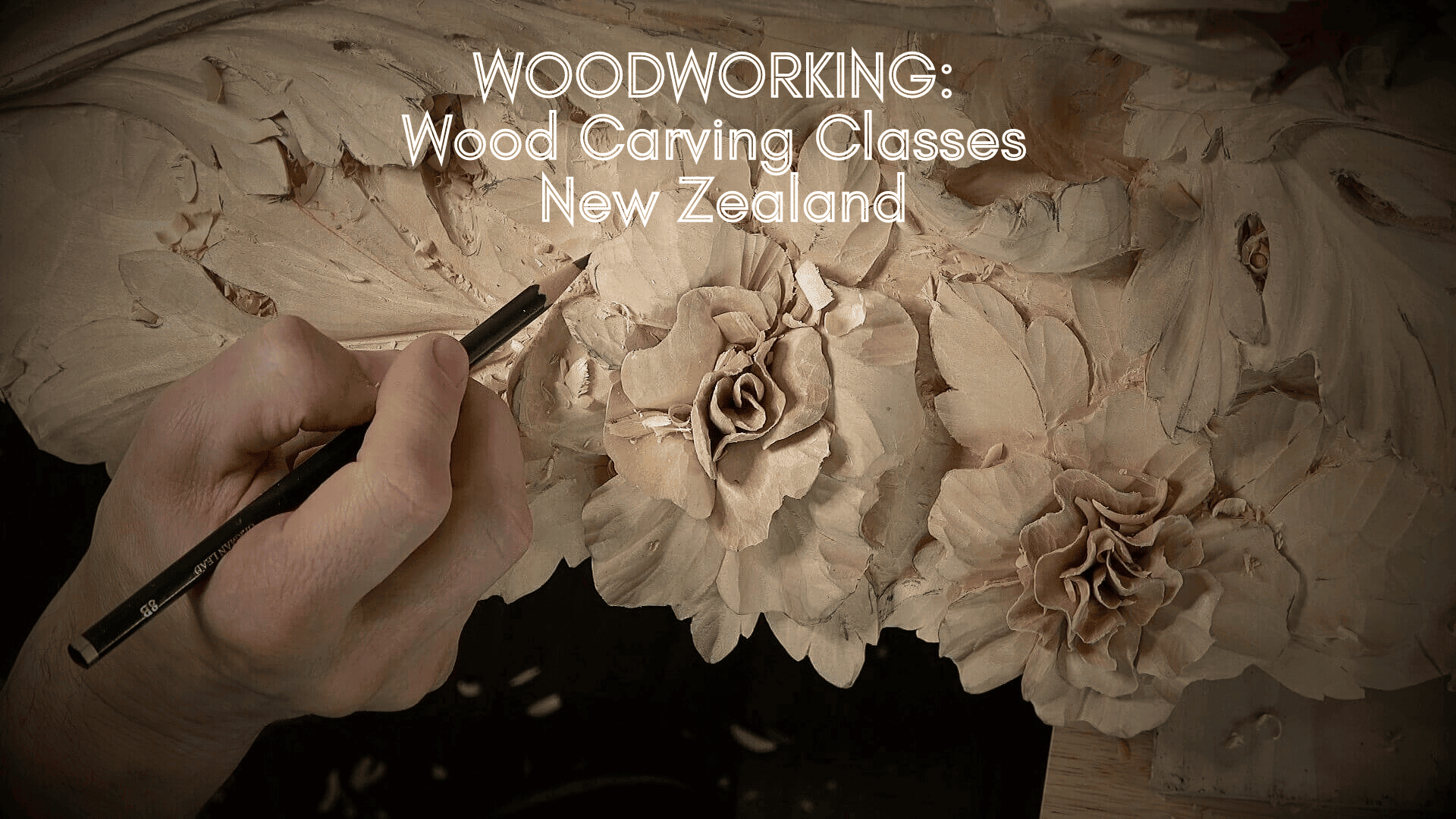 Hand working on a detailed wood carving featuring roses and leaves. This scene showcases a person using a pencil to outline design elements on a wood piece. The emphasis is on high-quality craftsmanship in wood carving. Perfect for promoting Wood Carving Classes and Wood Carving lessons in New Zealand!