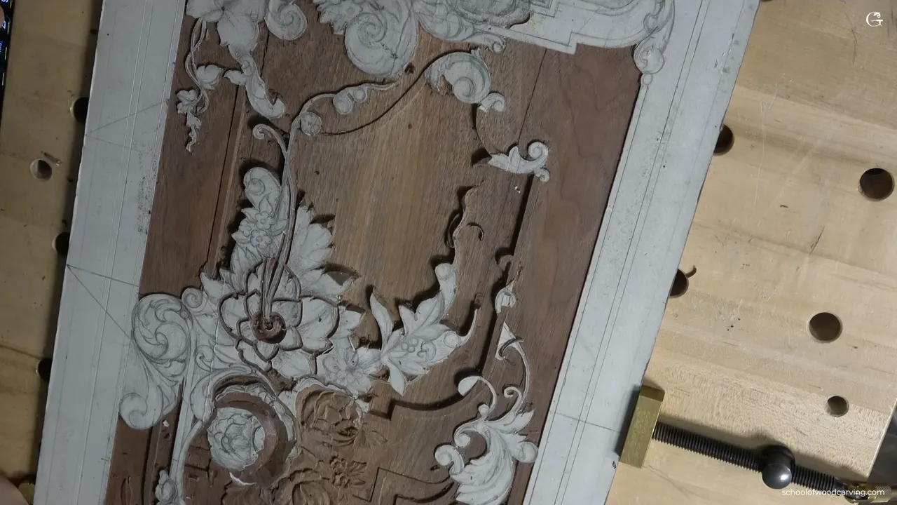 Nearly finished walnut panel on the bench, its main flower bouquet standing above a flat tooled ground.