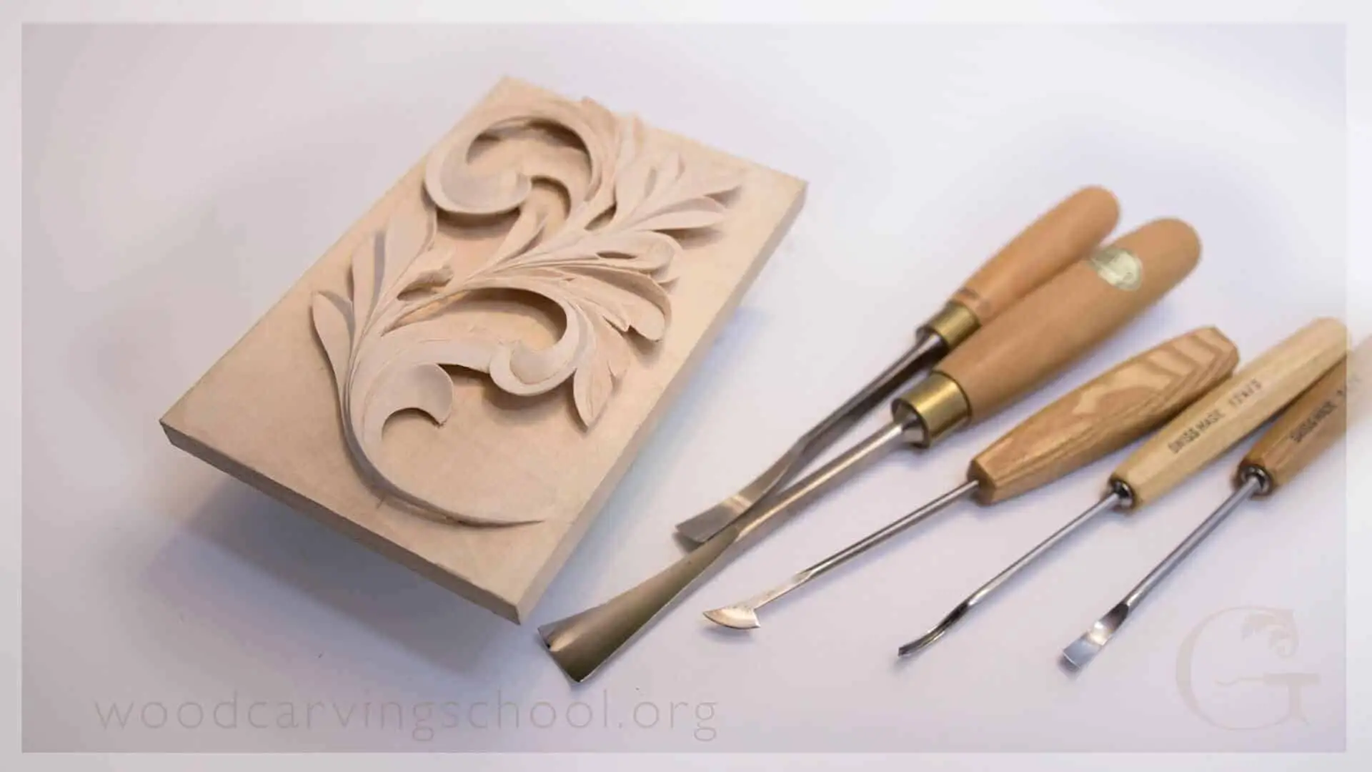Carved Greek acanthus leaf in lime wood beside the four gouges that did most of the work.