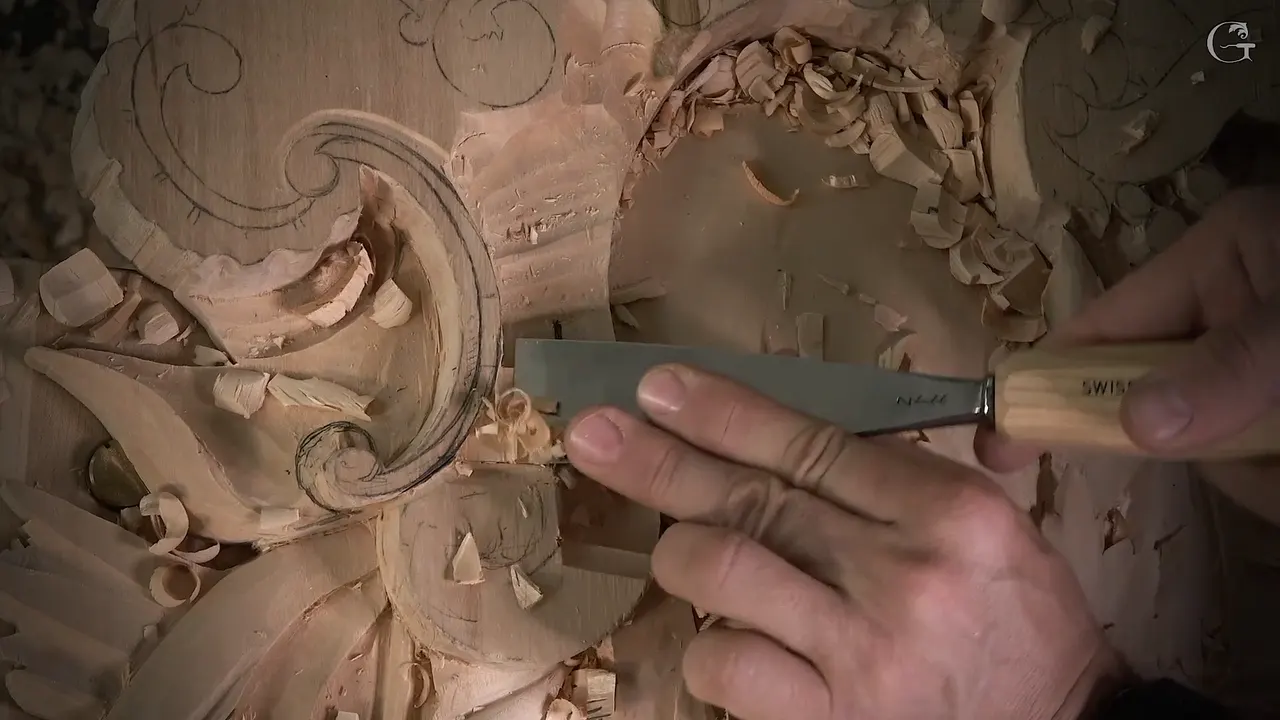 A wide, nearly flat gouge slides over the lowered wood under the volute