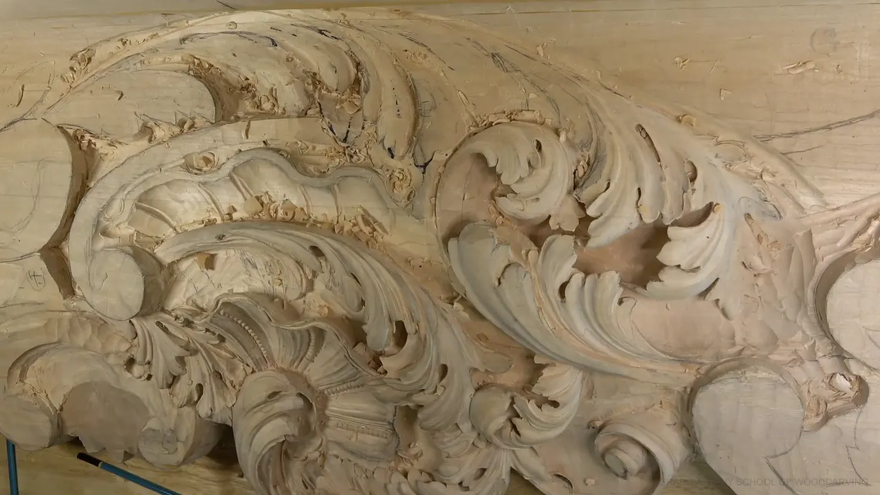 The carved board in full, acanthus leaves curling around a shell at its center, no hands in the way.