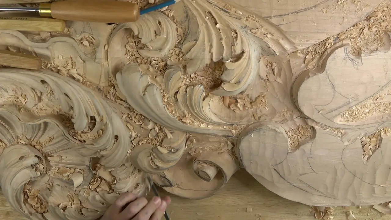 Top view of the ceiling board, with carved acanthus, a curled scroll and pencil outlines on the flat wood.