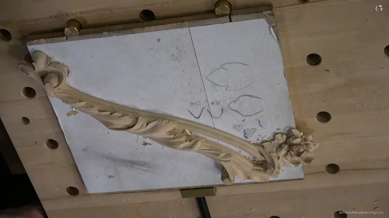 Carved acanthus leaf running corner to corner across its board, two molding profiles sketched beside it