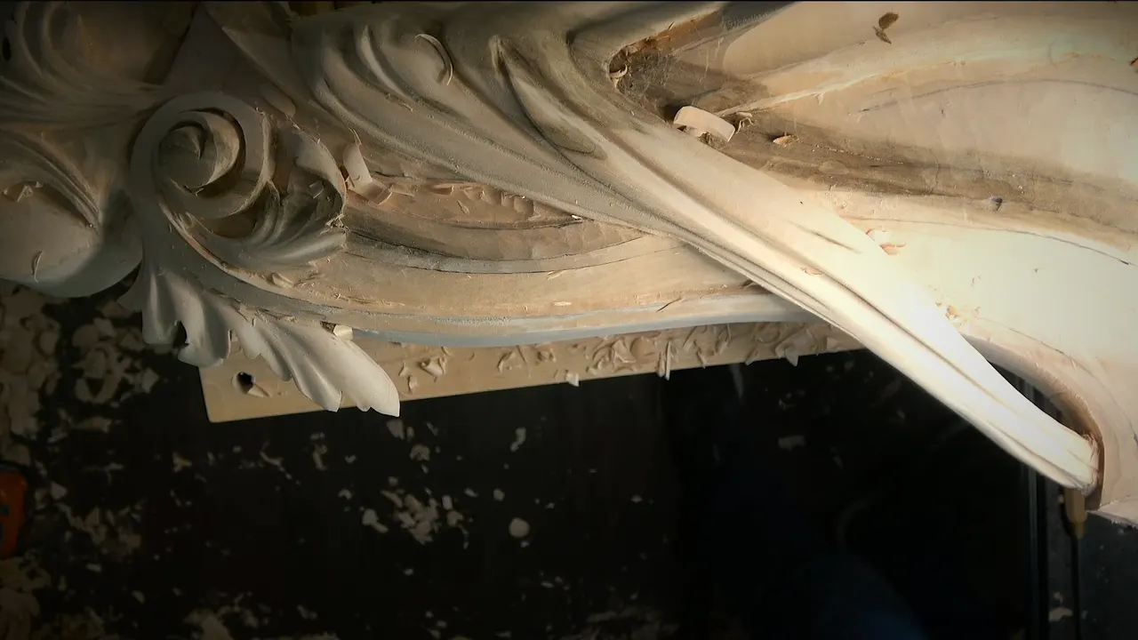 Corbel from above, a carved scroll and long leaf over a plain band