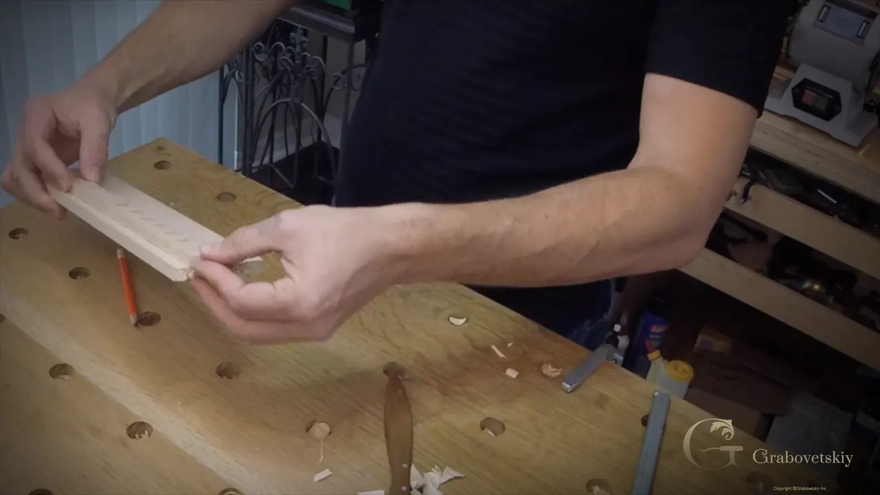Finished molding strip held in both hands over the bench