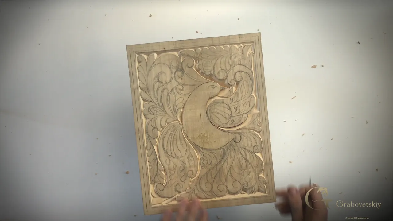Carved wing lifted clear of the ornament around it on a basswood panel.