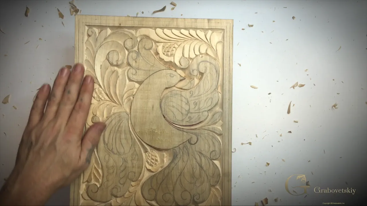 Carved basswood panel with both flowers finished and the ground worked right up to the bird.