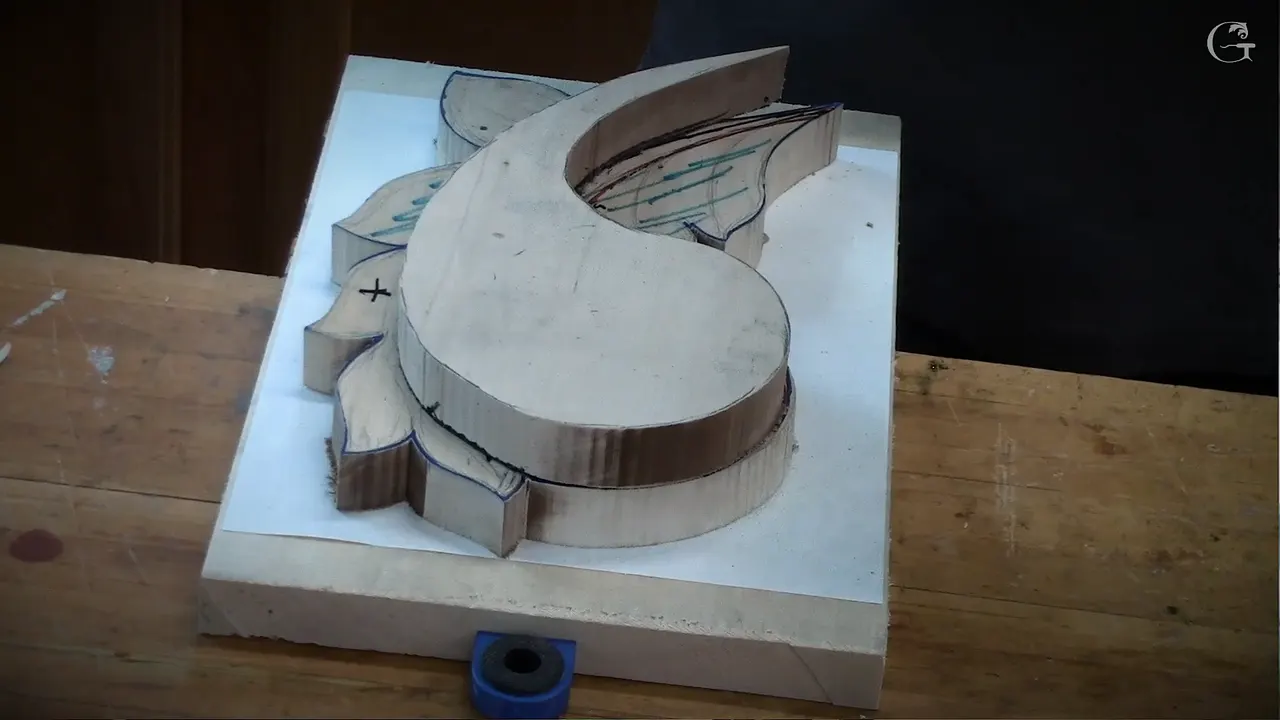 Stacked layers of a carved scroll sitting on the backing board