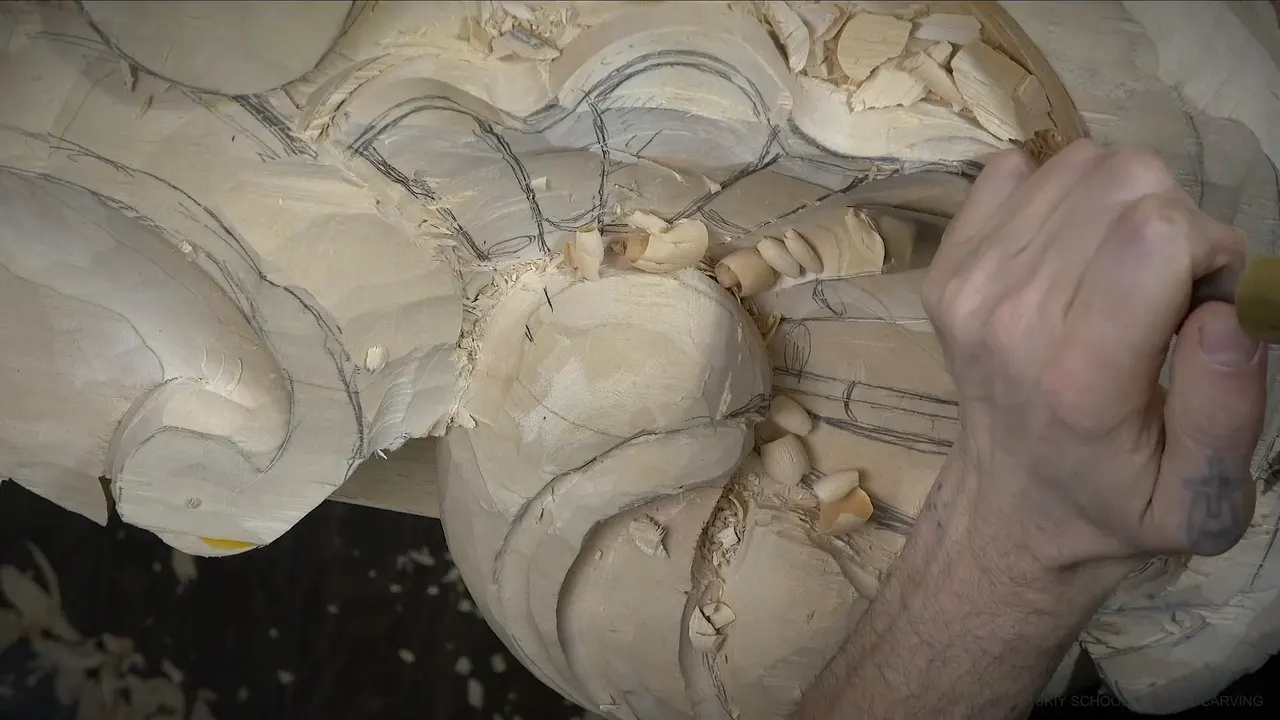 A gouge moves among pencil-marked ribs, with chips lying all around