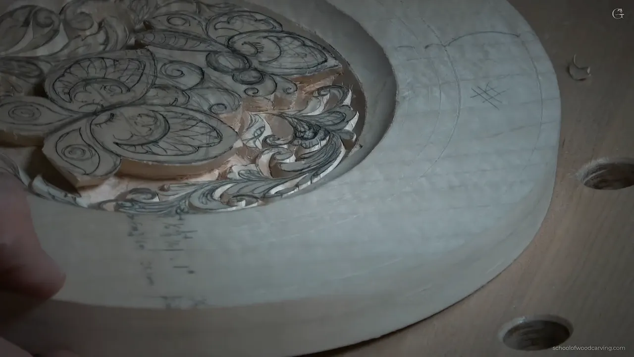 Seen low and from the side, deep carved curls beside raised butterflies still marked in pencil
