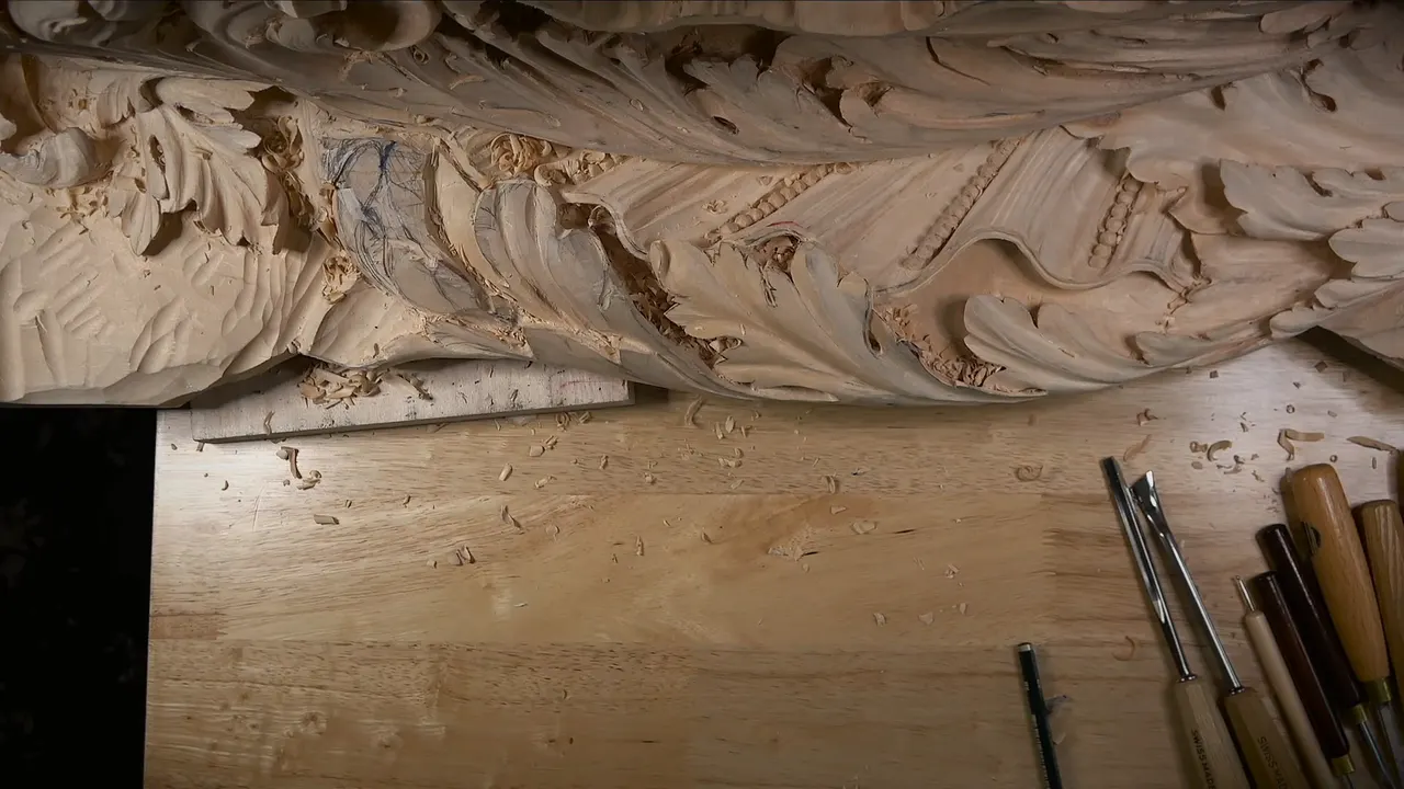 Carved acanthus band along a bench, a row of gouges lying below it
