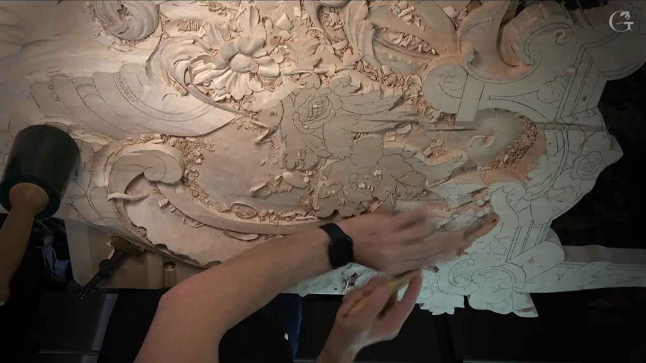 Whole panel from above, carved flowers up top, pencil leaves still flat below, a mallet parked on the left