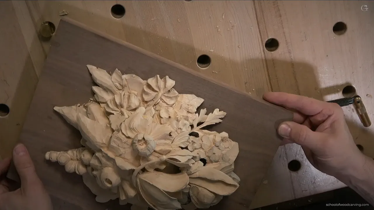 Parsley leaf and flowers on the Grinling Gibbons panel, the walnut board lifted off the bench and turned toward the light