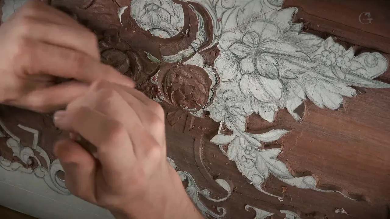 Hands blurred in motion over the half carved bloom, the drawn flowers waiting to the right