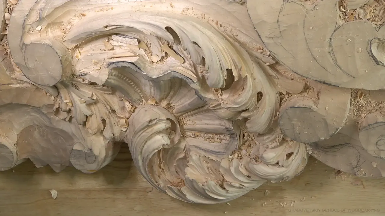 Top view of the carved shell with the big acanthus scrolls curling around it and chips on the bench.