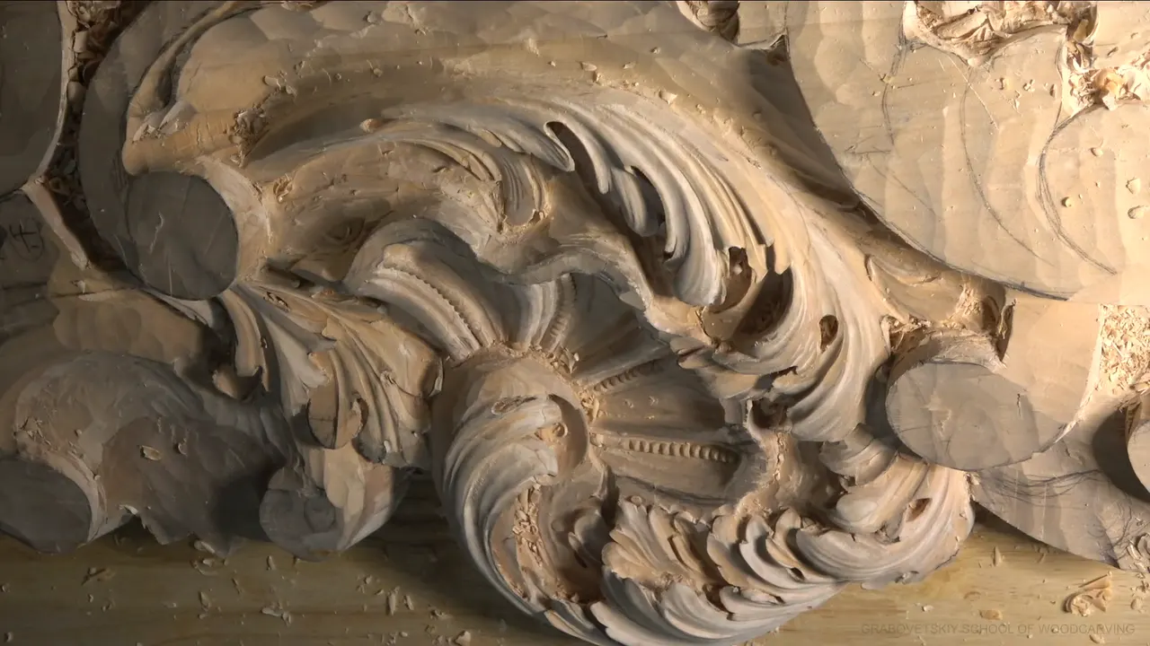Lime acanthus head under a low side light, deep shadow sitting in the curls and hollows.
