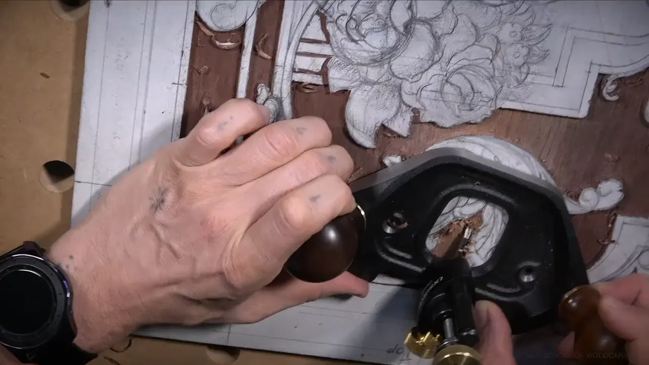 The last of the background going flat under a router plane held in both hands