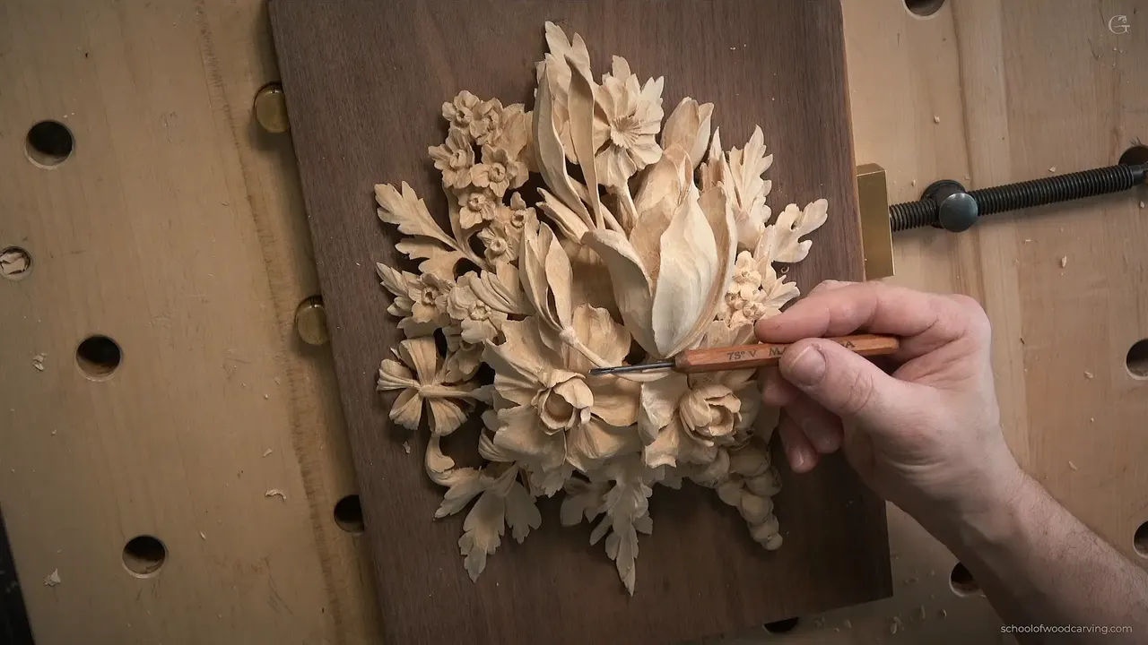 Near finished Gibbons style bouquet on a dark walnut ground, a tiny 75 degree V tool working between two petals