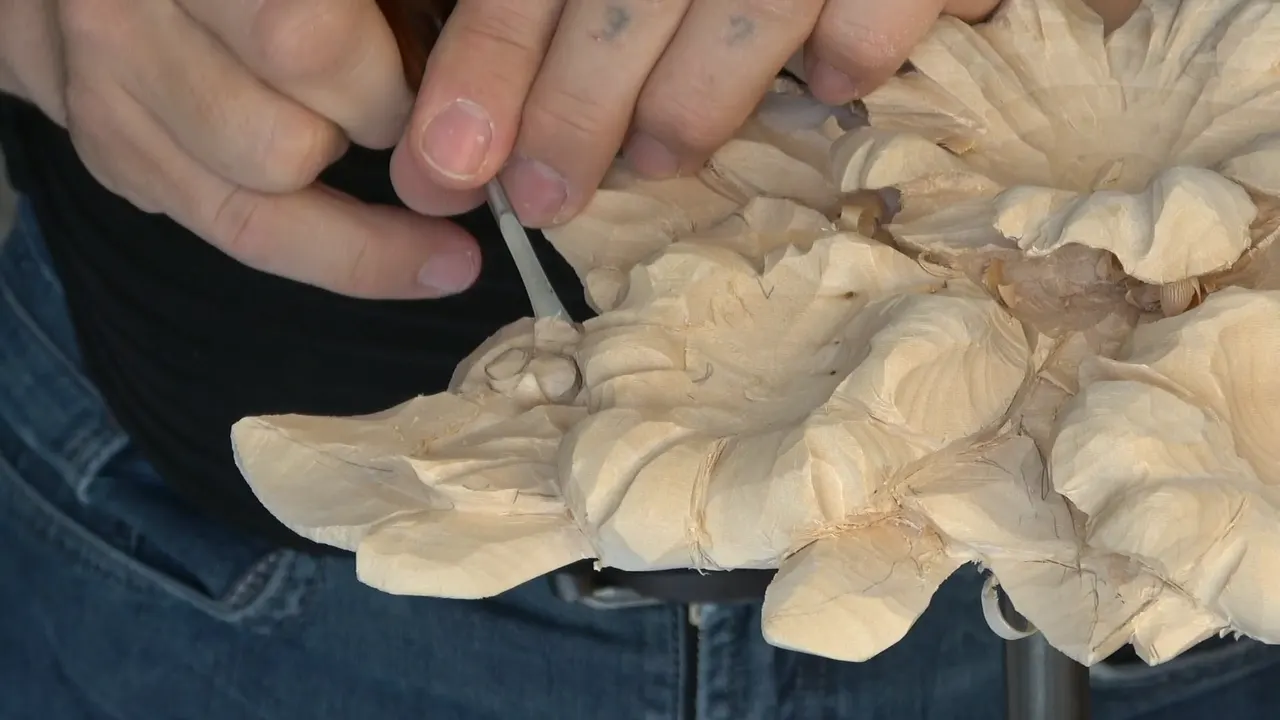 Both hands on a small tool, cleaning right up to the cut.