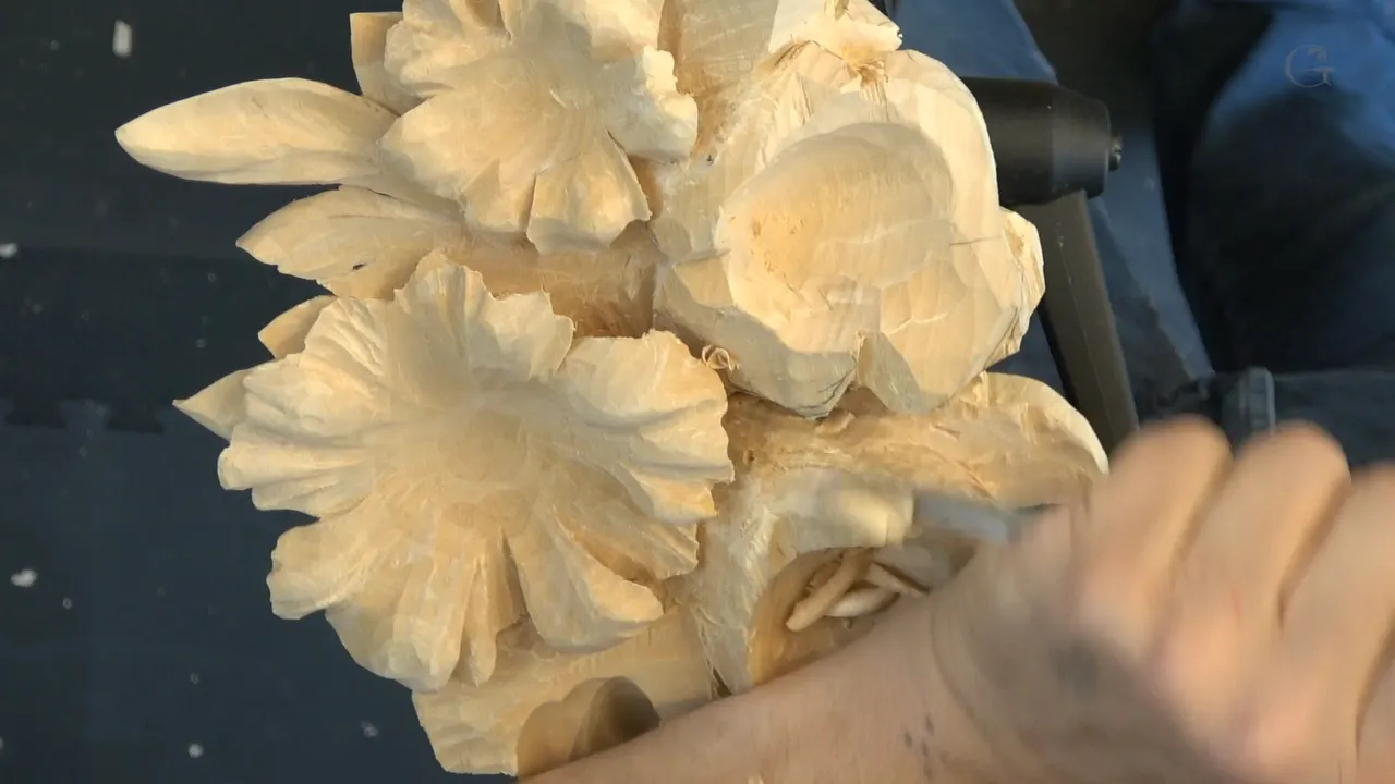 A gouge driven deep between two carved petals, where the shadow will sit.
