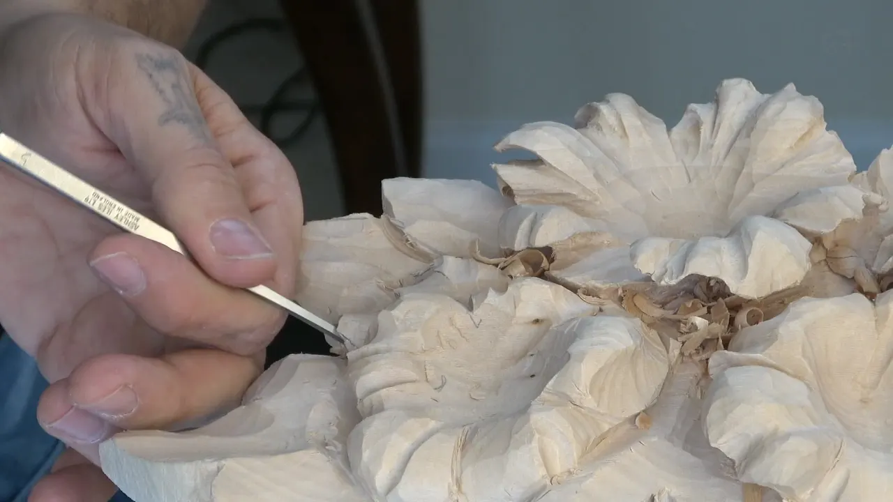 A small knife opening an undercut at the centre of a flower.