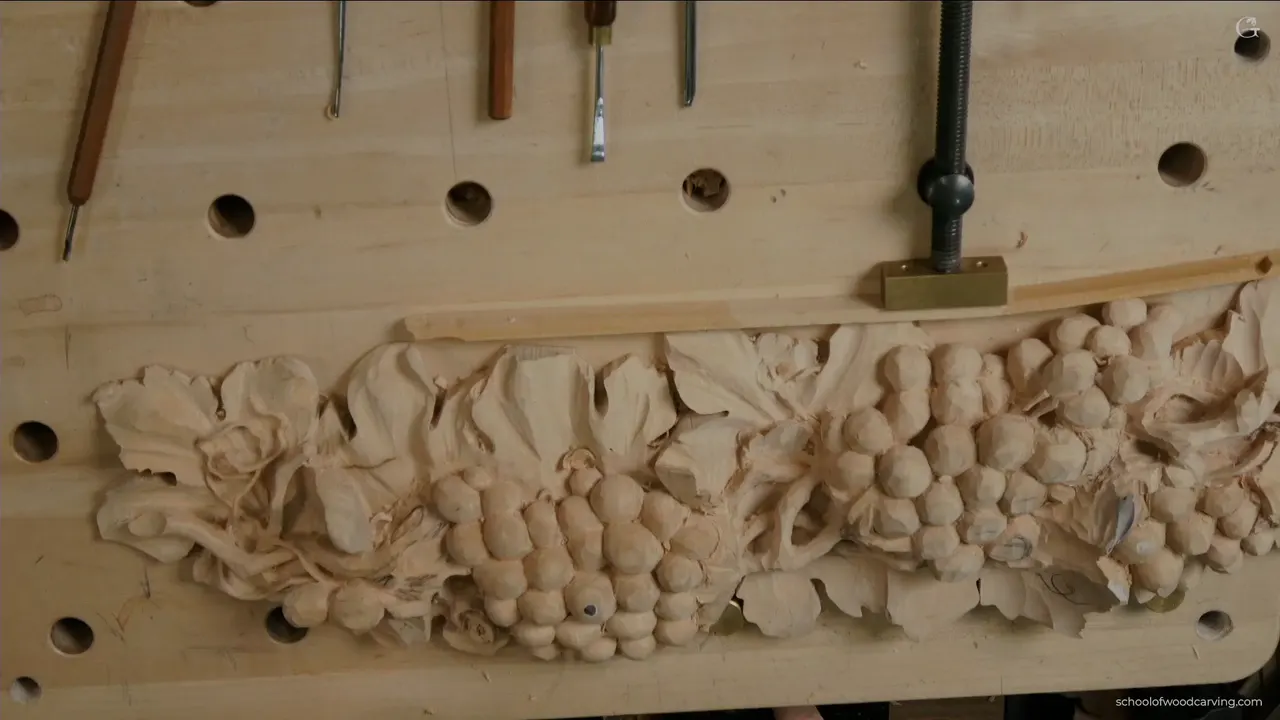 Whole carved run seen from above, every cluster finished and the vine weaving between them