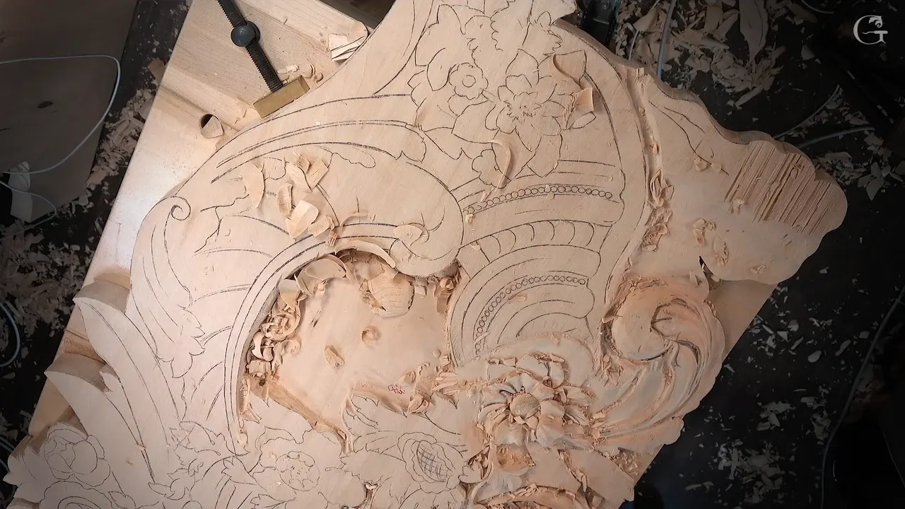 Panel from straight above, flowers and a scroll carved on one half and pencil drawing on the rest