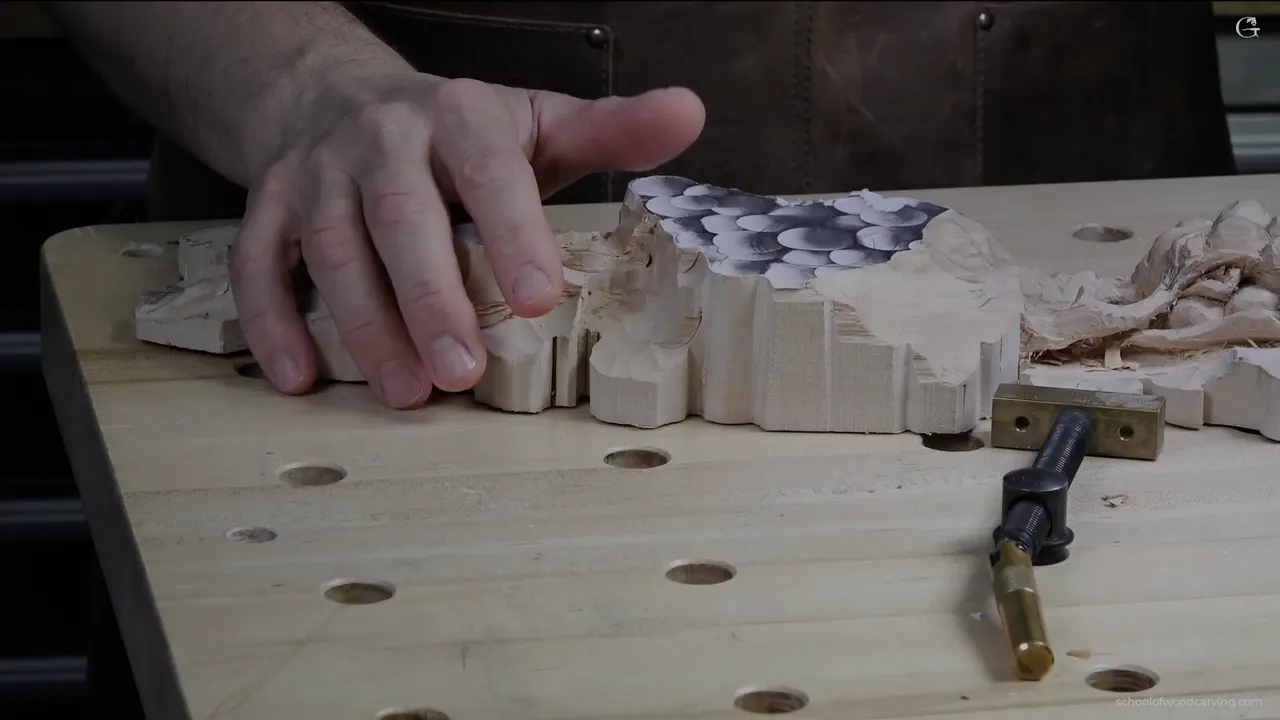 Both hands on the carving, which is exactly how three weeks of handling darkens the wood