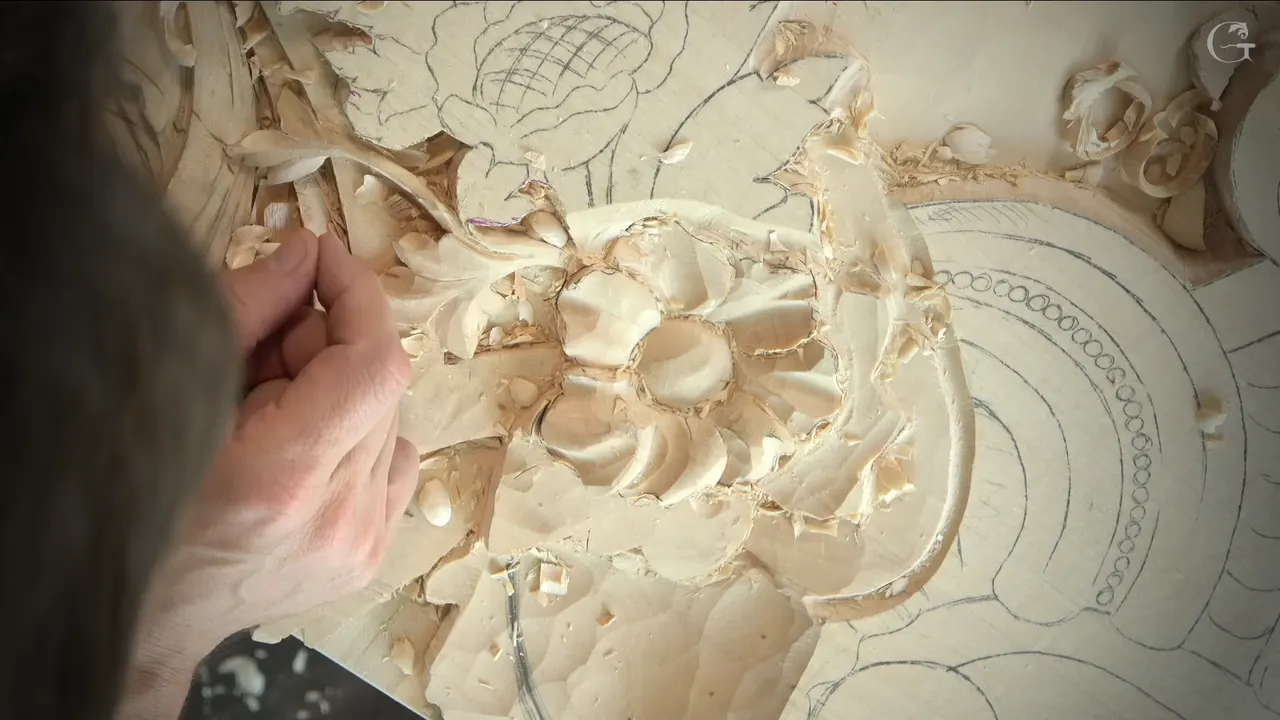 Fingers at the upper left of a small carved flower, seen from straight above