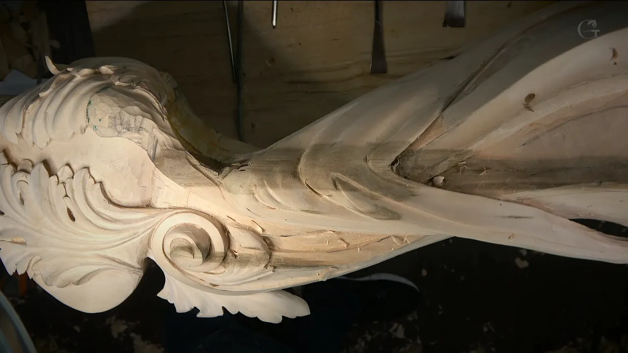 Side view of the carved corbel, a leafy scroll at left and long hollows running along the band