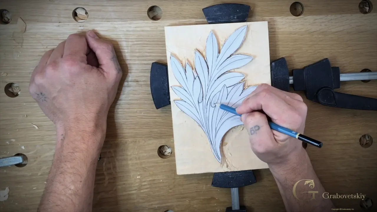 A pen points at the lower lobes of the paper drawing glued down on the basswood block.