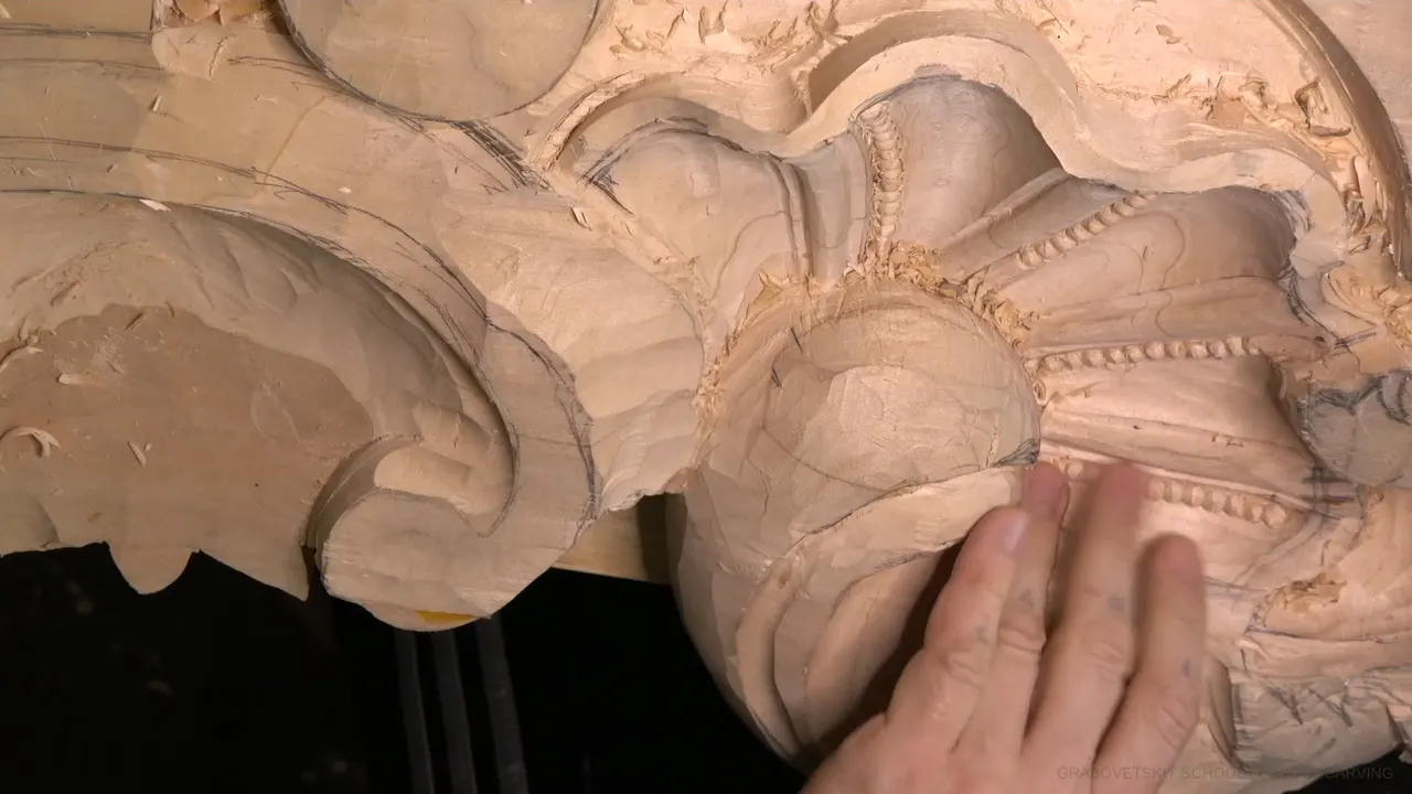 Rows of carved beads run across the shell with a hand laid flat beside them.