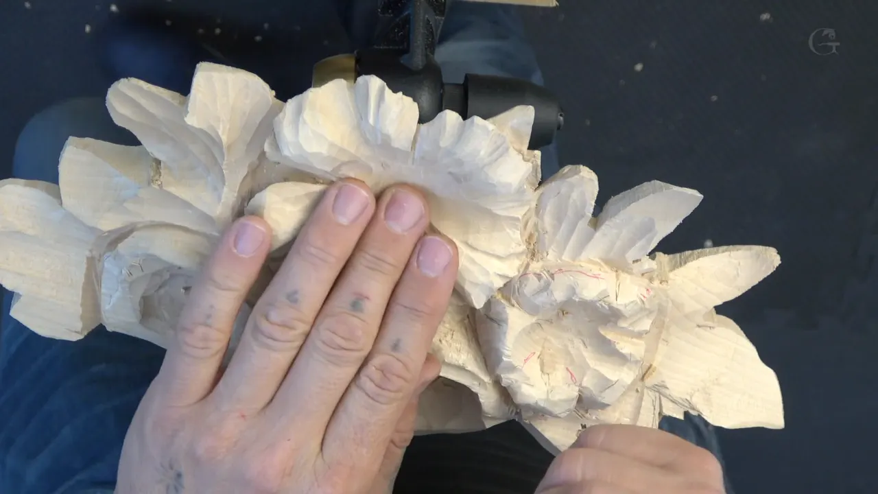 Both hands flat on the panel, four flowers roughed, red pencil marks over on one of them
