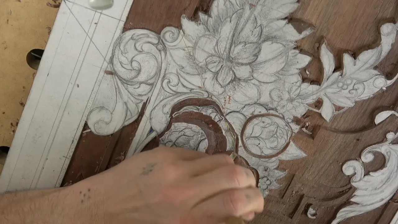 A hand across the board, two small round blooms outlined in brown pencil beside the big drawn bouquet