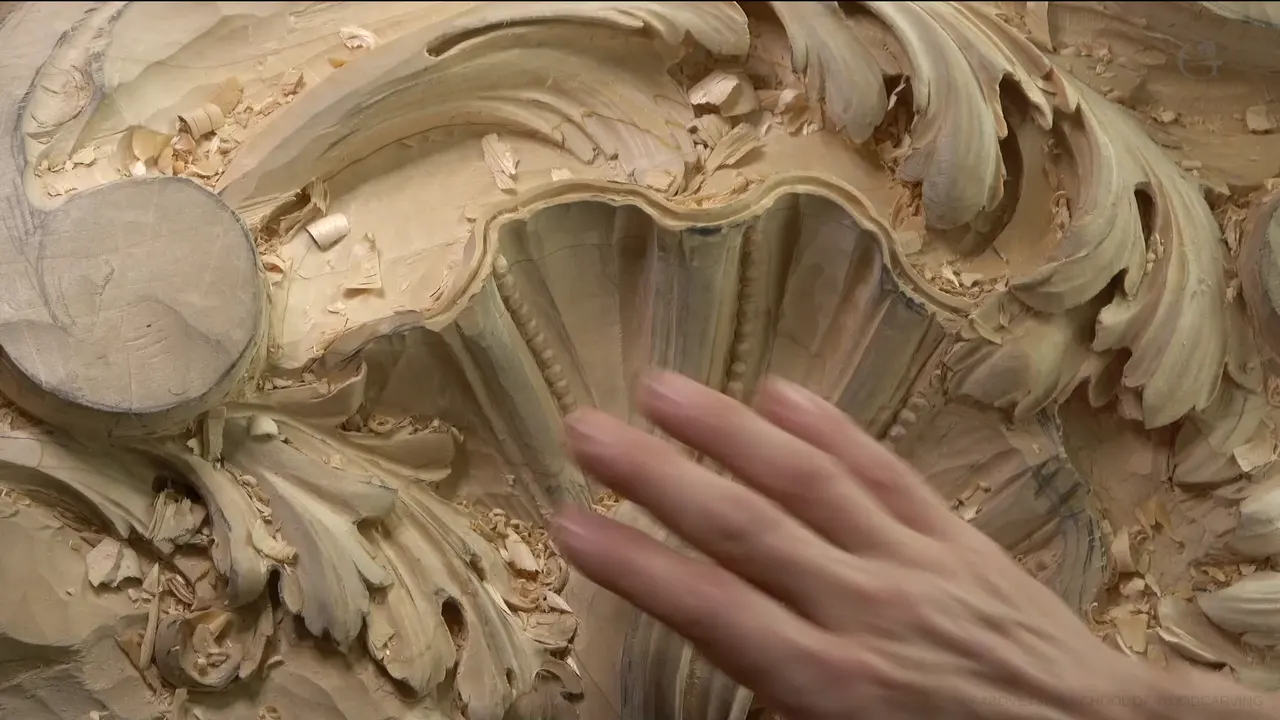 An open hand beside the shell, its thin rim standing just above a dark groove.