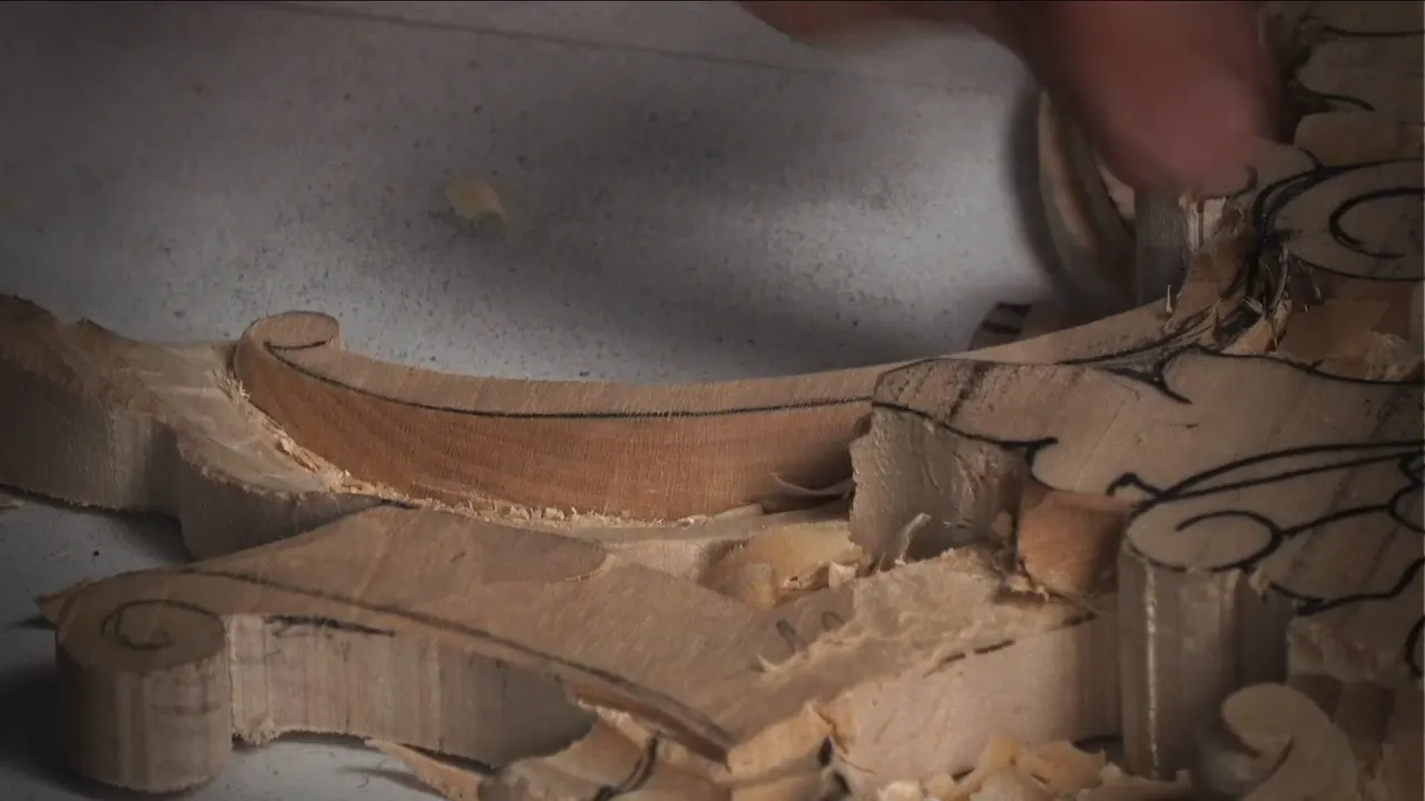 Volute and molding carved down to depth, the drilled holes gone and the surface left smooth by a sharp gouge