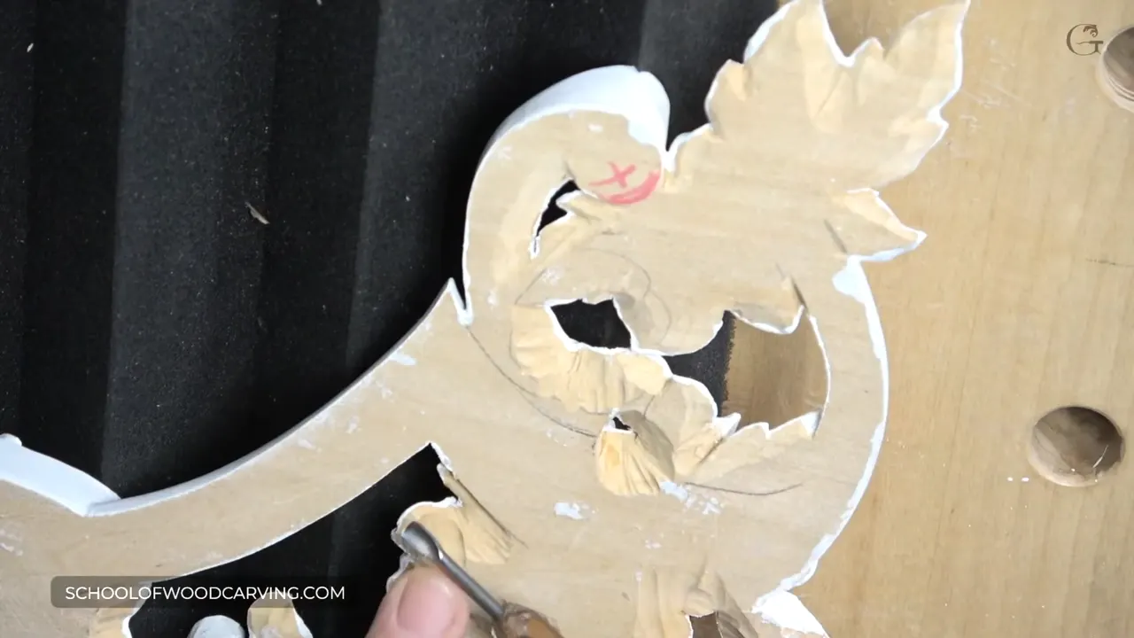 Carving turned face down on a sheet of black studio foam while a small gouge works the back of it