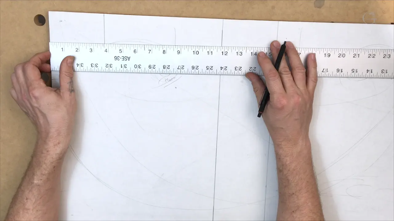Steel rule laid flat across the papered panel, pencil ready in the other hand