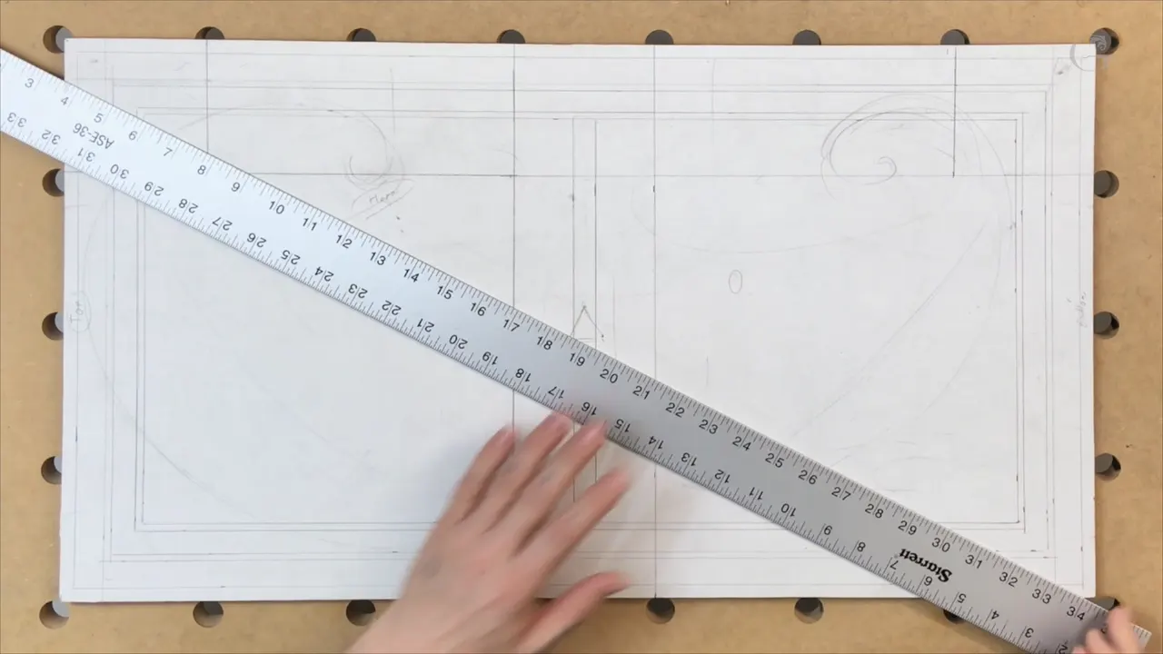 Long steel rule laid corner to corner across the bordered panel with both hands holding it down