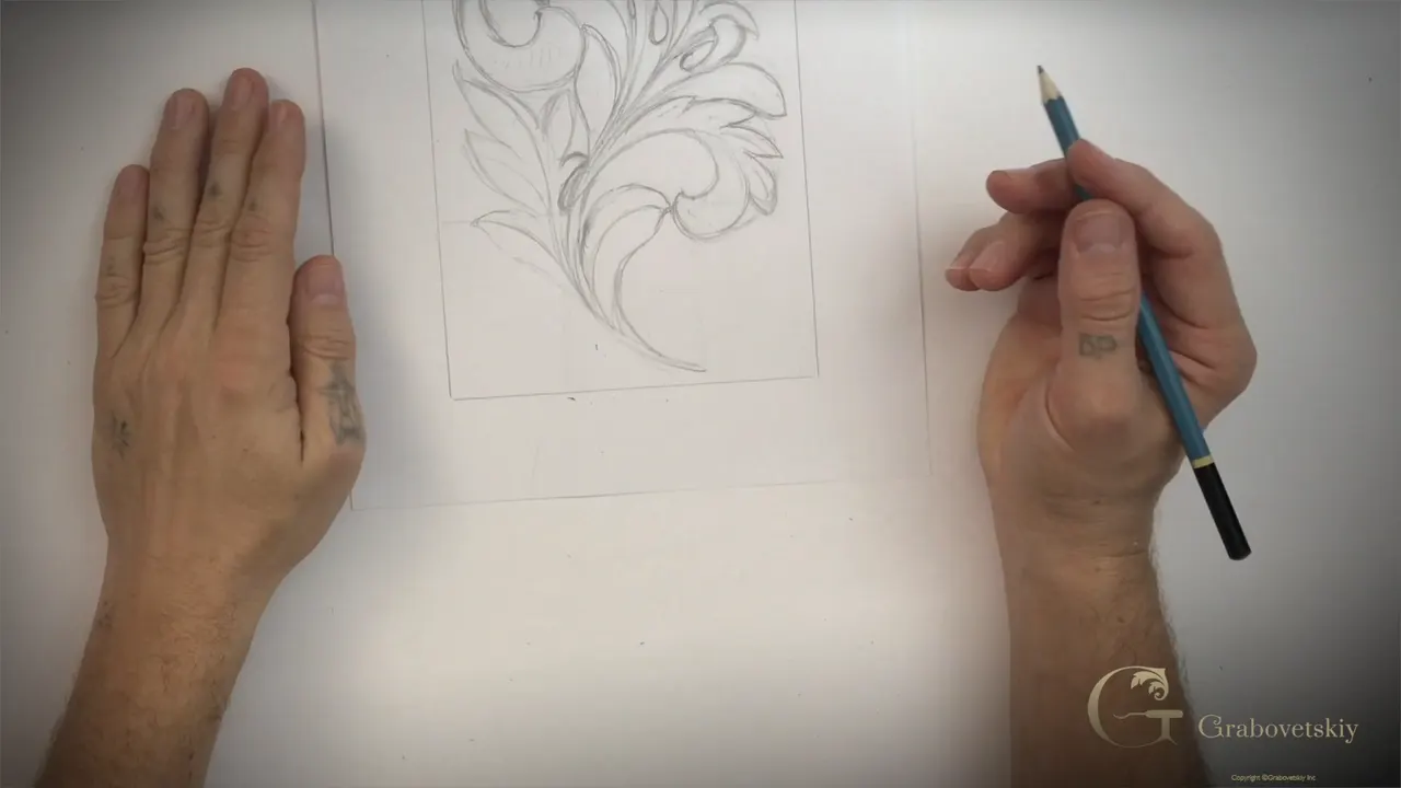 The finished Greek acanthus drawn in pencil on a sheet of paper with a hand resting at either side