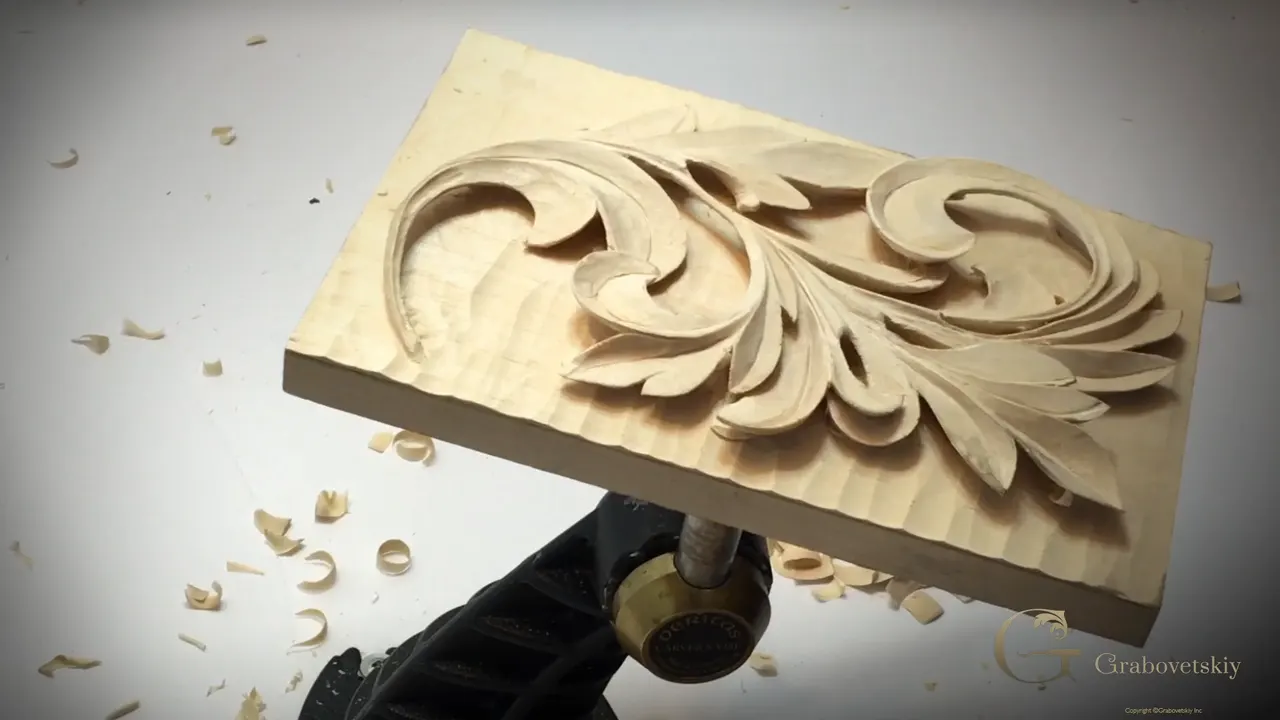 Panel lying flat on the vise with the background carved down and no hands in the picture