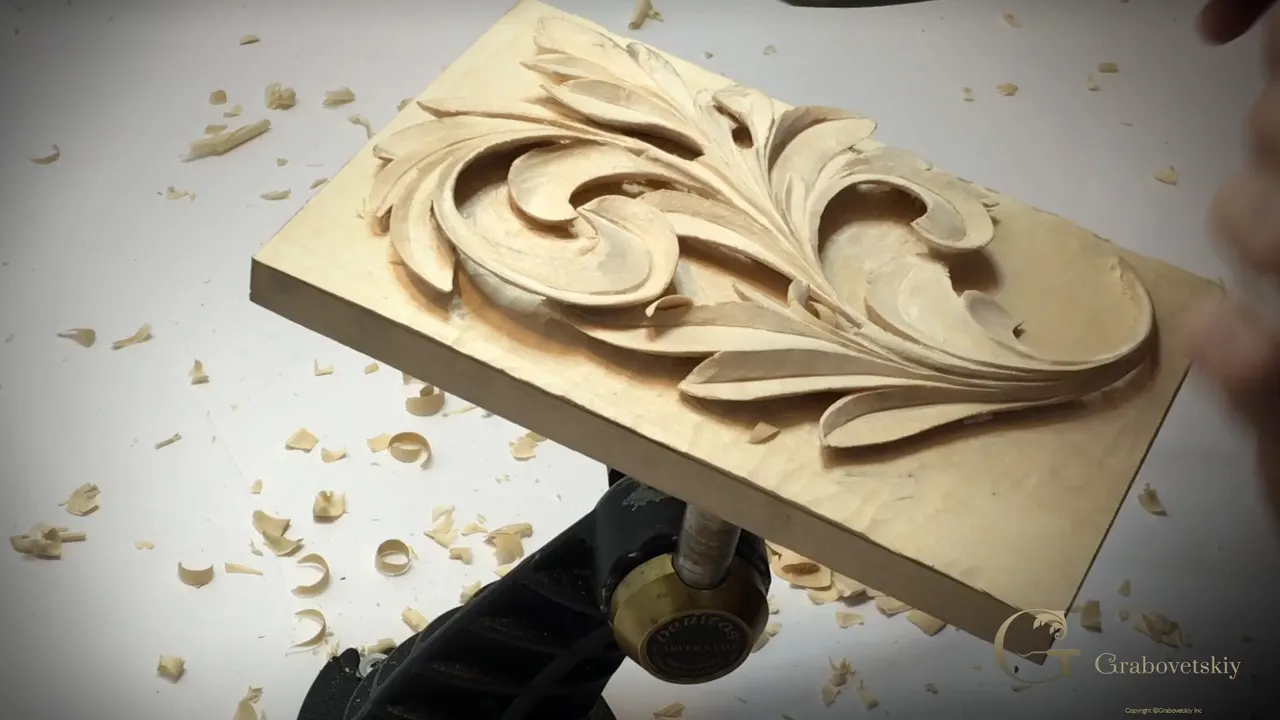 Finished acanthus panel flat on the bench with the ground cleaned and nobody's hands in shot