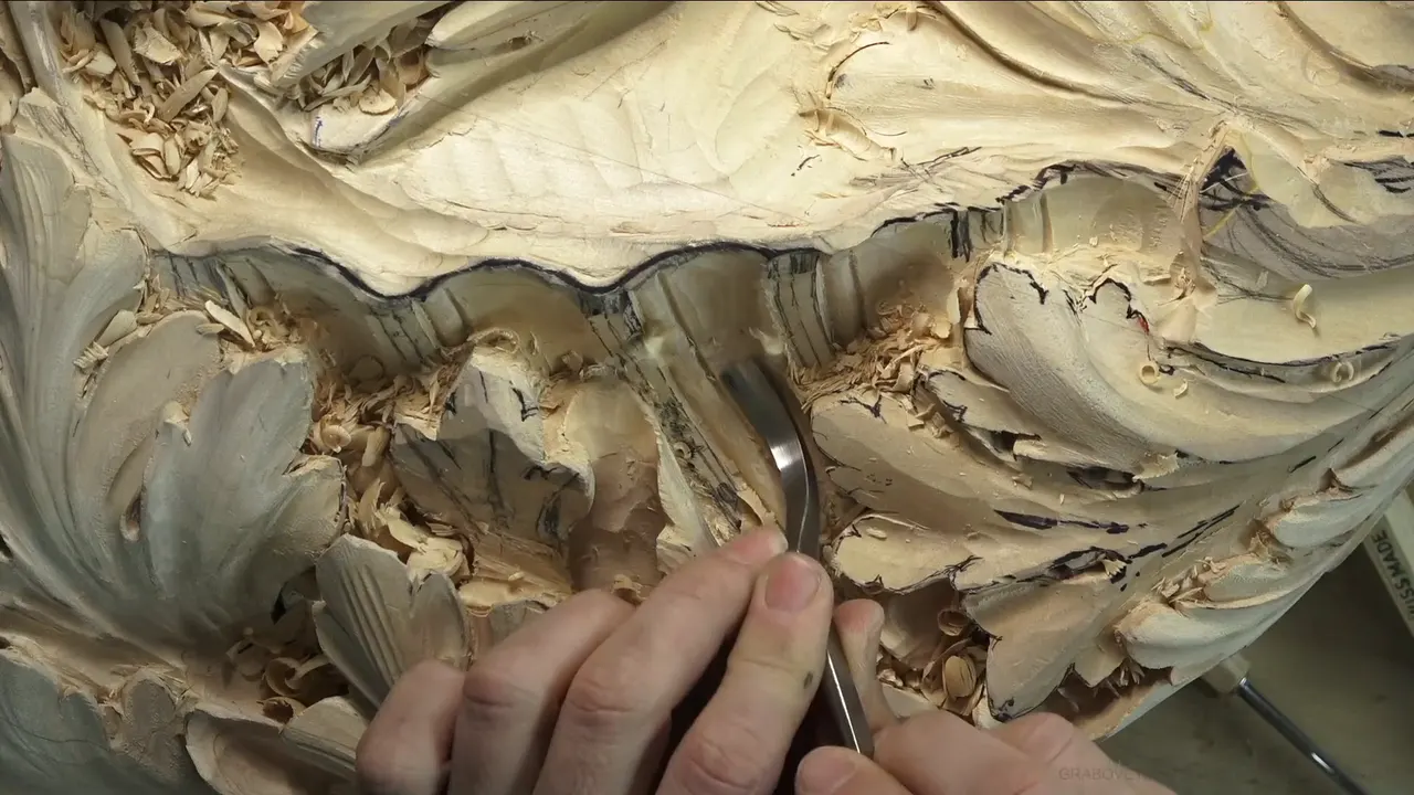 A bent gouge in the fingers, rounding the strip below the shell's rim.