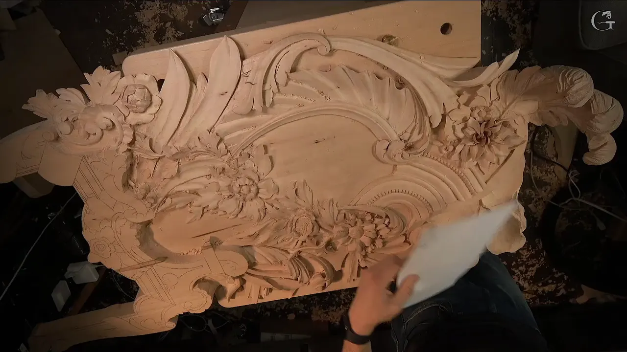 Whole panel seen from above with three feathers, a shell and a run of beads already carved